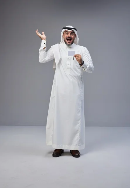 رجل سعودي يحمل بطاقة تعريف فارغة بتعبير مندهش