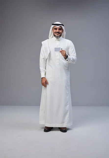 رجل سعودي بالزي التقليدي يحمل بطاقة تعريف فارغة
