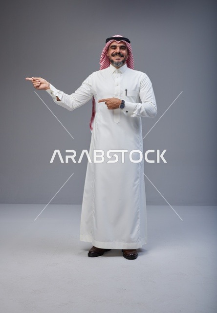 Saudi Man in Traditional Thobe Pointing in Studio