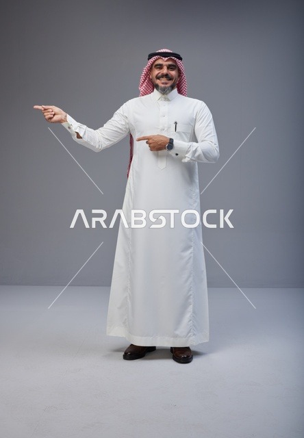 Smiling Saudi Man Pointing in Traditional Dress