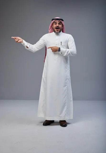 رجل سعودي بالزي التقليدي يشير بتعبير وجه مندهش