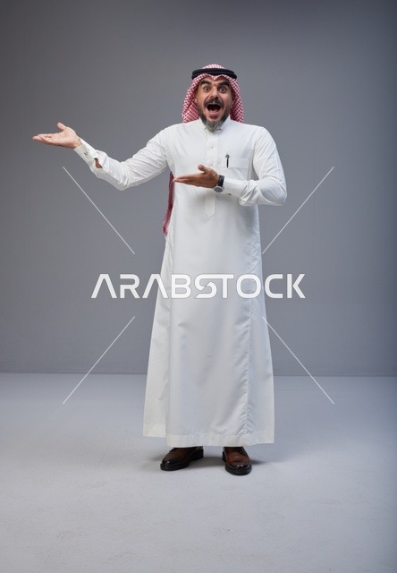 رجل سعودي بالزي التقليدي يشير بتعابير مندهشة