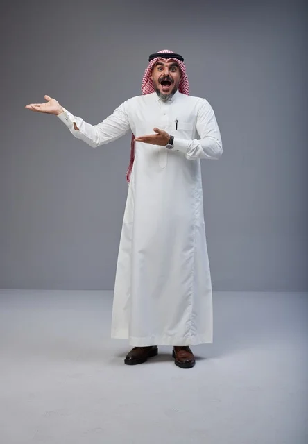 رجل سعودي بالزي التقليدي يشير بتعابير مندهشة