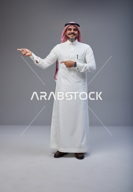 Saudi Man in Traditional Thobe Pointing in Studio
