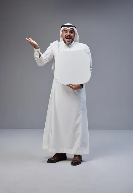 رجل سعودي يحمل لوحة فارغة بتعبير وجه مندهش