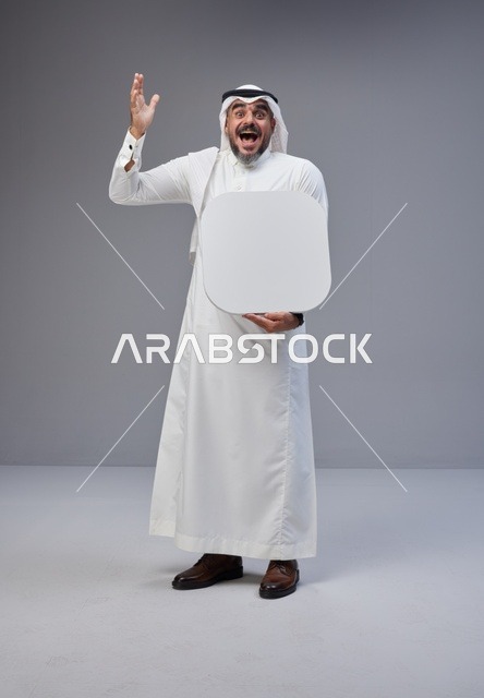 رجل سعودي يحمل لوحة بيضاء فارغة في الاستوديو