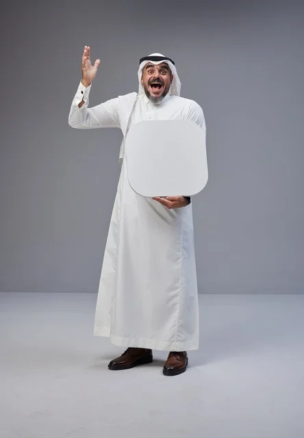 رجل سعودي يحمل لوحة بيضاء فارغة في الاستوديو