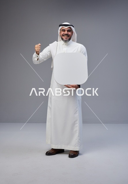 رجل سعودي يحمل لوحة بيضاء فارغة في الاستوديو