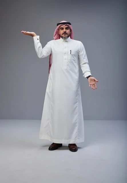 رجل سعودي بالزي التقليدي في استوديو بخلفية رمادية
