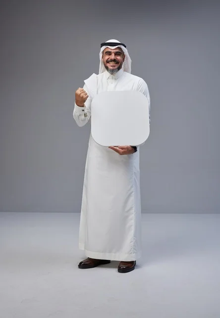 رجل سعودي يحمل لوحة بيضاء فارغة في الاستوديو رجل سعودي يحمل لوحة بيضاء فارغة في الاستوديو
