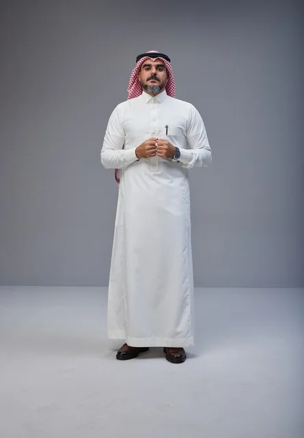 رجل سعودي بالزي التقليدي يقف في استوديو