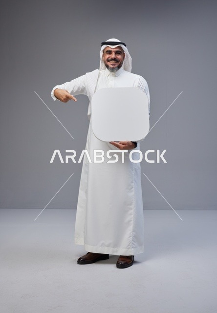 رجل سعودي بالزي التقليدي يحمل لوحة فارغة