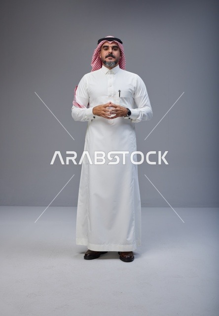 رجل سعودي بالزي التقليدي يقف في استوديو تصوير