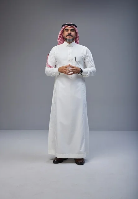 رجل سعودي بالزي التقليدي يقف في استوديو تصوير