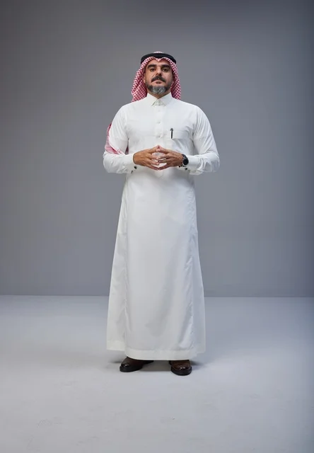 رجل سعودي بالزي التقليدي في خلفية رمادية