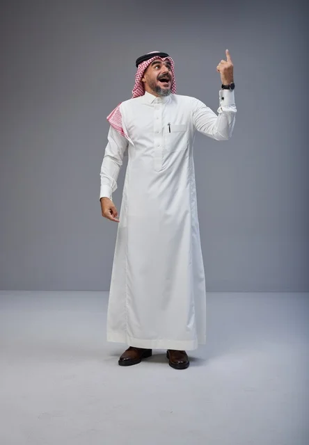 Saudi Man in Traditional Thobe Pointing Up in Studio