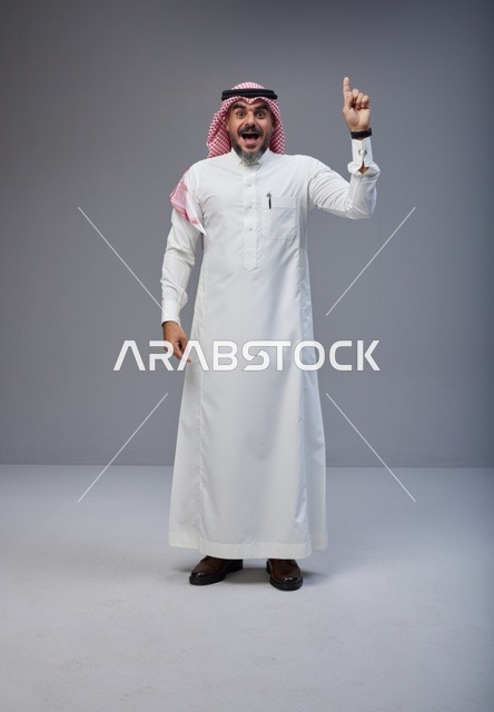 رجل سعودي بالزي التقليدي يشير للأعلى بدهشة