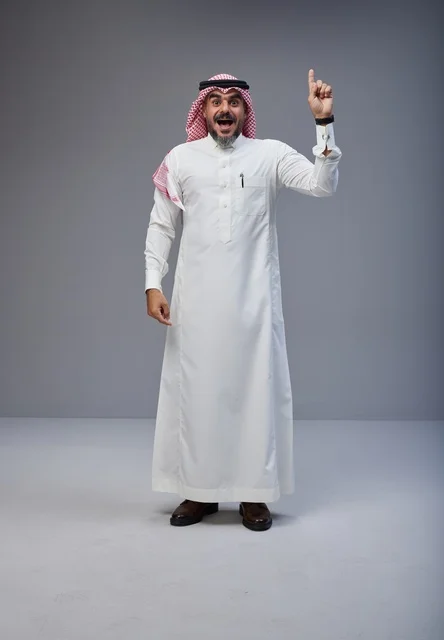 رجل سعودي بالزي التقليدي يشير للأعلى بدهشة