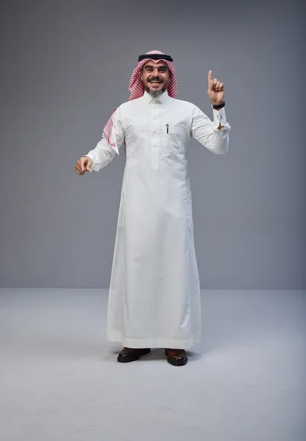 رجل سعودي بالزي التقليدي يشير للأعلى في الاستوديو