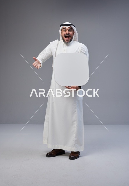 رجل سعودي يحمل لوحة بيضاء فارغة في الاستوديو