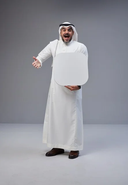 رجل سعودي يحمل لوحة بيضاء فارغة في الاستوديو