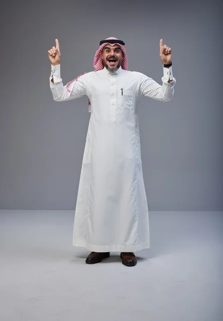 رجل سعودي بالزي التقليدي يشير للأعلى