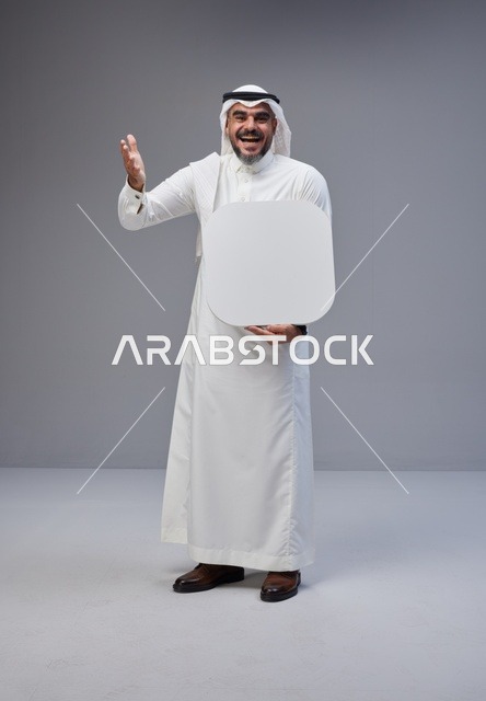 رجل سعودي يحمل لوحة بيضاء فارغة في الاستوديو