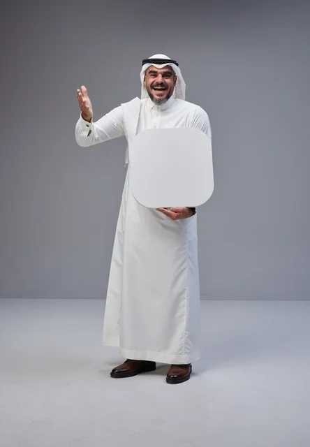رجل سعودي يحمل لوحة بيضاء فارغة في الاستوديو