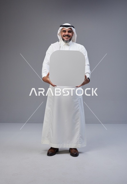 رجل سعودي بالزي التقليدي يحمل لوحة بيضاء فارغة