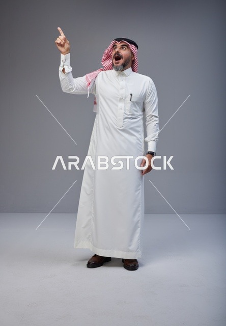 Surprised Saudi Man Pointing Up in Traditional Dress