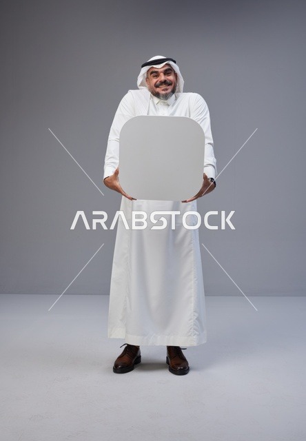 رجل سعودي بالثوب التقليدي يحمل لوحة بيضاء فارغة