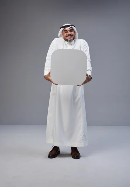 رجل سعودي بالثوب التقليدي يحمل لوحة بيضاء فارغة