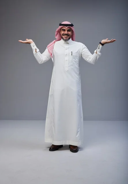 رجل سعودي بالزي التقليدي يبتسم في استوديو