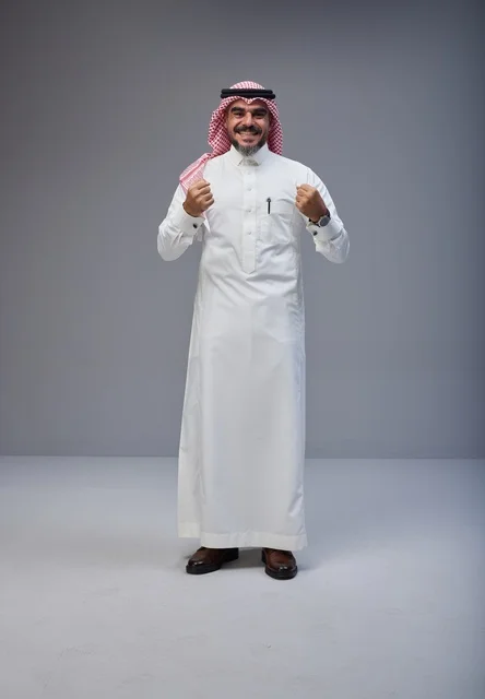 رجل سعودي بالزي التقليدي يحتفل بالنجاح في الاستوديو