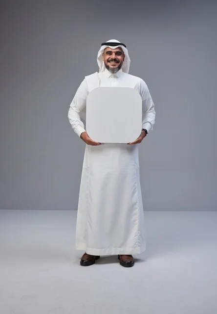 رجل سعودي يحمل لوحة بيضاء فارغة في الاستوديو