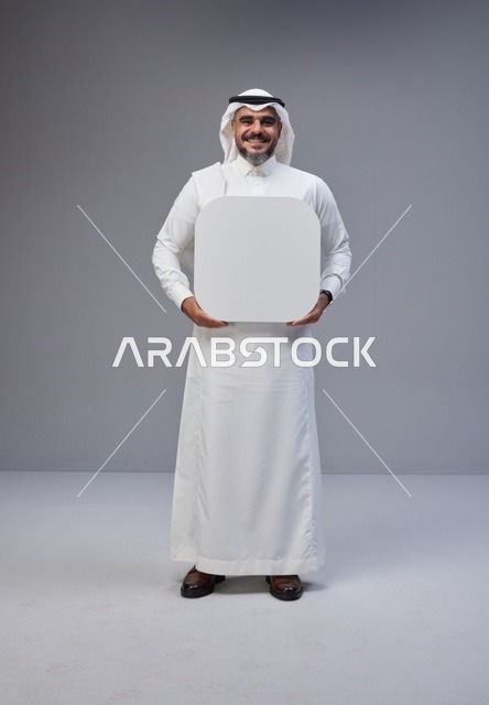 رجل سعودي بالزي التقليدي يحمل لوحة بيضاء فارغة