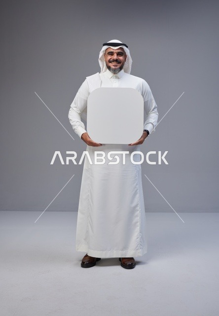 رجل سعودي بالزي التقليدي يحمل لوحة بيضاء فارغة
