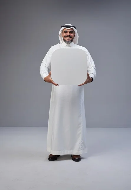 رجل سعودي يحمل لوحة بيضاء فارغة في الاستوديو