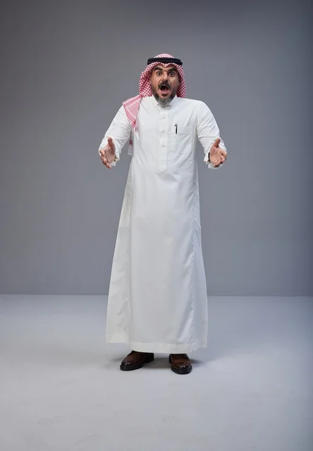 Shocked Saudi Man in Traditional Dress on Grey Background Shocked Saudi Man in Traditional Dress on Grey Background
