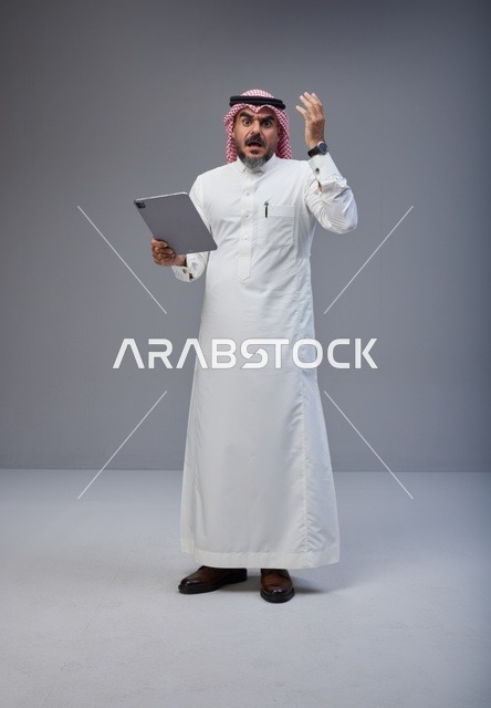 رجل سعودي مصدوم يستخدم جهاز لوحي في الاستوديو