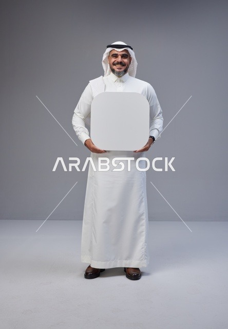 رجل سعودي بالزي التقليدي يحمل لوحة فارغة