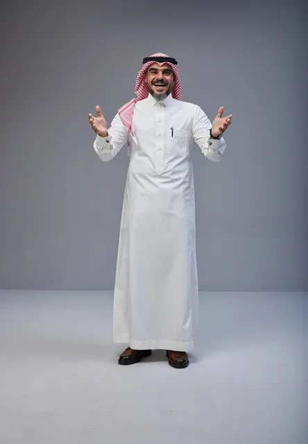 رجل سعودي بالزي التقليدي يبتسم في الاستوديو