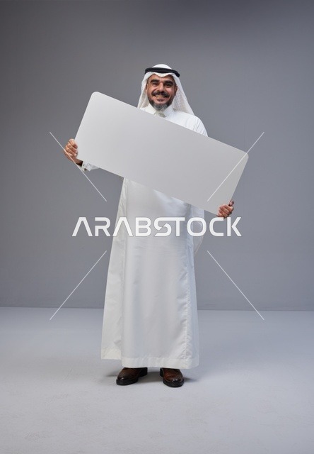 رجل سعودي بالزي التقليدي يحمل لوحة بيضاء فارغة