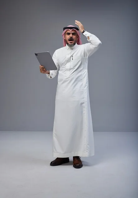 Saudi Man in Traditional Thobe Holding Tablet