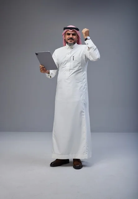 Saudi Man with Tablet Celebrating Success in Studio