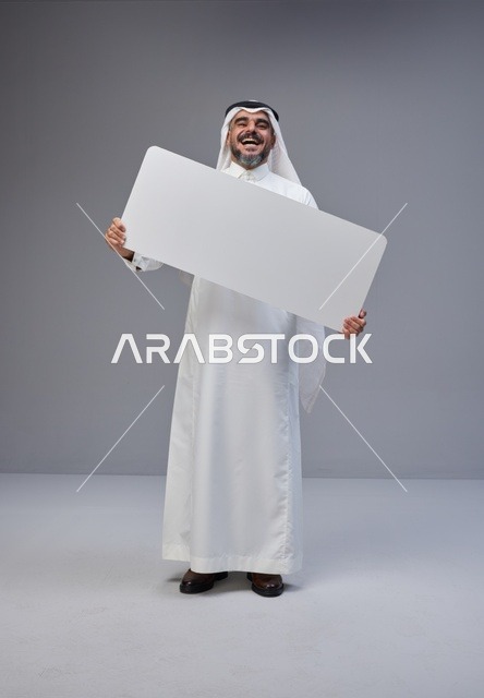 رجل سعودي بالزي التقليدي يحمل لوحة بيضاء فارغة