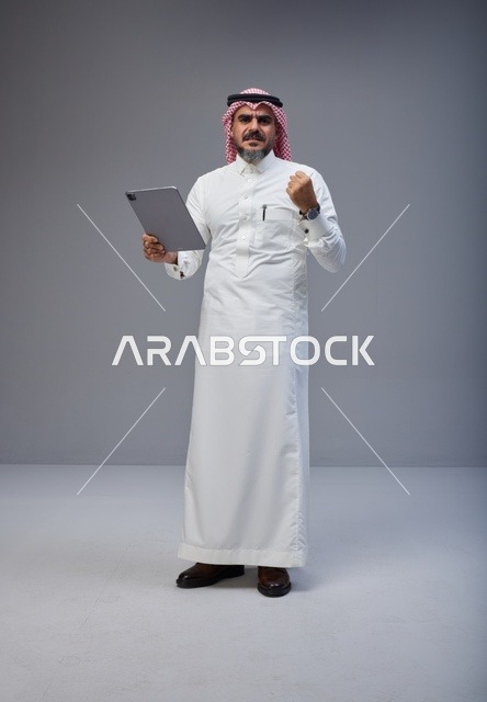 Saudi Man with Tablet Celebrating Success in Studio