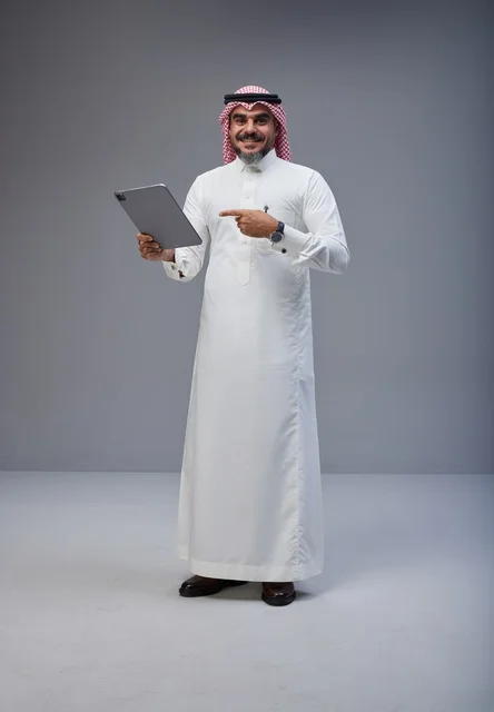 Saudi Man in Traditional Thobe Using Digital Tablet
