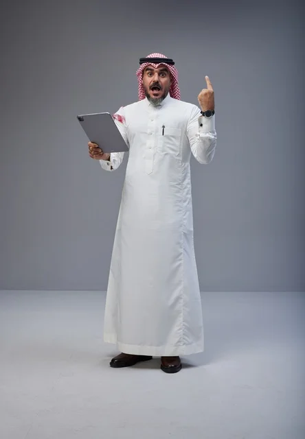 Saudi Man in Traditional Dress Using Tablet in Studio