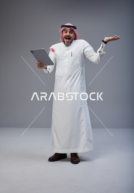 Excited Saudi Man with Tablet in Traditional Dress